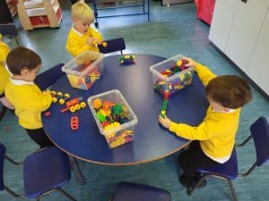 Children playing with colorful building blocks at Inchmarlo childcare center.