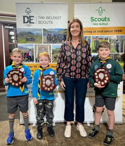 Scouts kids holding award shields with leader at Inchmarlo Scout Center.