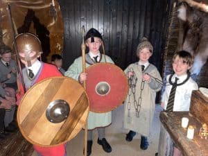 Children dressed as Vikings with shields and helmets at Inchmarlo heritage site.