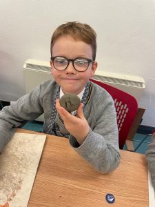 Young boy with glasses enjoying a chocolate treat at Inchmarlo Care Home.