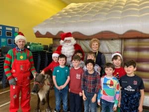 Festive holiday scene with children, Santa, and staff at Inchmarlo resort.