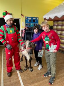 Children and Santa with a Reindeer at Inchmarlo Christmas event in Scotland.