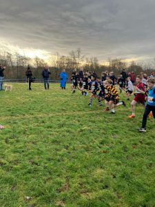 Children playing rugby outdoor in Inchmarlo school field, active kids enjoying sports.