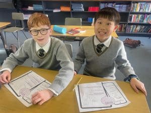 Two happy students studying in classroom at Inchmarlo School, promoting quality education and student success.