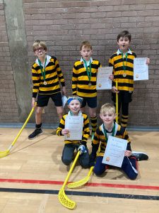 Smiling children holding certificates in sports uniforms at Inchmarlo school.