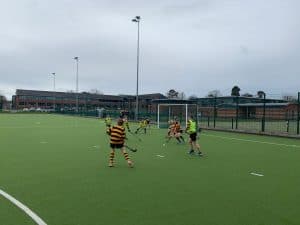 Children playing hockey on Inchmarlo sports field in Scotland, outdoor activity and sports facilities.