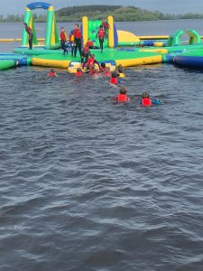 People enjoying water activities at Inchmarlo park's inflatable water park.