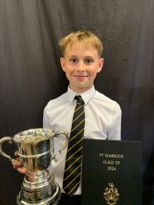 Young student with trophy at Inchmarlo School, celebrating achievement.