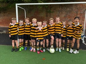 Group of children in rugby uniforms on a soccer field at Inchmarlo, showcasing youth sports and community spirit.