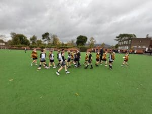 Children playing football on Inchmarlo school field under cloudy sky.