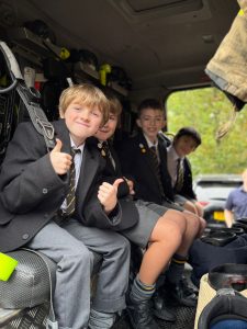 Group of children smiling inside a vehicle at Inchmarlo School in Scotland.