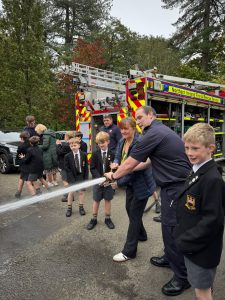 Children and firefighters participate in a fun fire safety demonstration at Inchmarlo.
