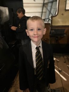 Young boy in school uniform smiling at Inchmarlo, a prestigious educational institution.