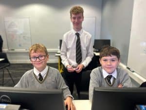 Students working at computers in a classroom at Inchmarlo School, showcasing academic excellence and a modern learning environment.