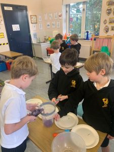 Children preparing food in school kitchen.