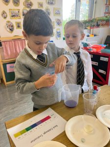 Two young boys conducting a science experiment in a classroom setting.