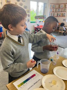 Two children conducting a science experiment in classroom.
