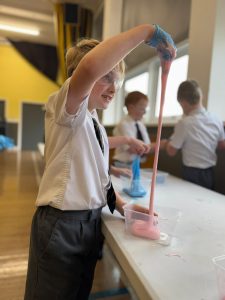Young girl performing a science experiment with colorful slime at Inchmarlo School.