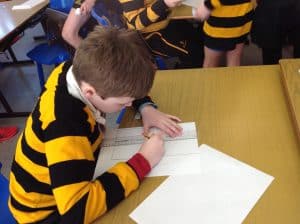 Young students in a classroom engaging with reading and writing activities.