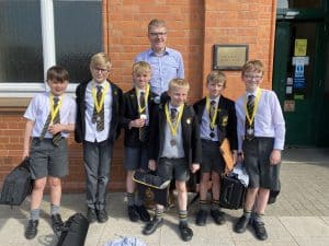 Students in school uniforms with backpacks and medals at Inchmarlo School.