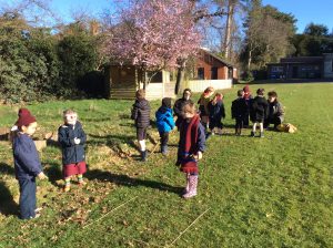 Children playing outside at Inchmarlo estate with greenery and trees in the background.