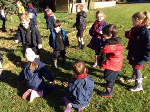 Young children playing outdoors at Inchmarlo school in a sunny, green playground.