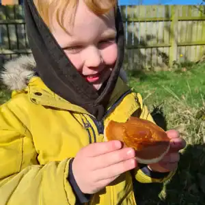 Child enjoying a honey gingerbread treat outside.