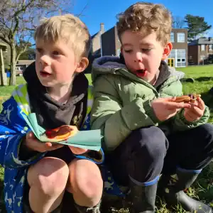 Two young children enjoying outdoor snacks in a park at Inchmarlo.