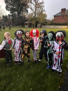Children dressed in colorful costumes at the Inchmarlo event. Elegant outdoor setting with trees and historic buildings in the background.