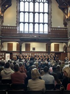Historic Inchmarlo hall hosting a large audience. Elegant architecture, natural light, and community events.