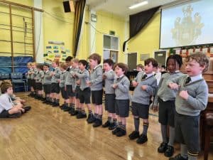 Young students performing in a classroom presentation.