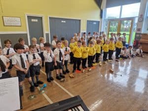 Children performing in school assembly at Inchmarlo, showcasing a vibrant and engaging learning environment.