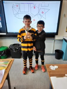 Two boys holding a trophy in a classroom at Inchmarlo.