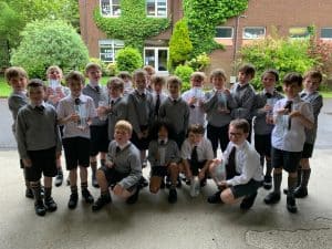 Group of students outdoors at Inchmarlo School in a lush green setting.