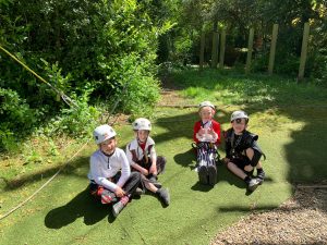 Four children enjoying outdoor activities in Inchmarlo estate's lush green grounds.