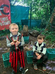 Two children sitting outdoors in a lush green area at Inchmarlo.