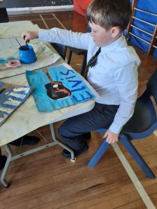 Young boy painting at Inchmarlo care home.