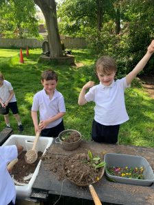 Children engaging in outdoor gardening activity at Inchmarlo estate, highlighting nature, family fun, and Scottish heritage.