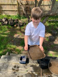 Young boy playing with sandbox outdoors, enjoying nature and outdoor activities at Inchmarlo.