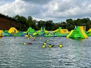 Vibrant inflatable waterpark on a lake at Inchmarlo, perfect for family fun and outdoor adventures.