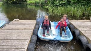 Children enjoying boating at Inchmarlo lakeside. Family-friendly vacation spot in scenic surroundings.