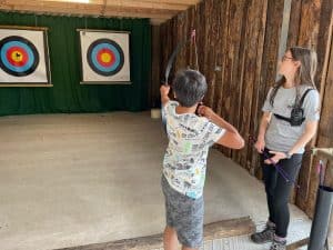 Children enjoying archery at Inchmarlo estate. Fun family outdoor activity with targets and bows.
