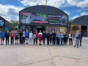 Group of children and adults at Inchmarlo outdoor event, enjoying activities and entertainment.