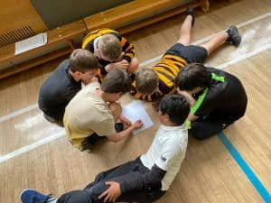 Students working together on an educational activity in a school gym.