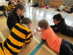 Children learning in school classroom environment with teacher guidance.