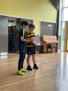 Two boys reading a map in a spacious indoor area at Inchmarlo Junior School.