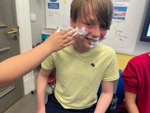 Child smiling at Inchmarlo School during fun activity.