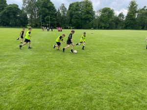 Children playing soccer on lush green field at Inchmarlo.