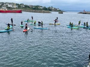 People paddleboarding at Inchmarlo on the scenic coast of Scotland.