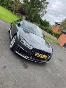 Black sports car parked outside Inchmarlo estate in Scotland.